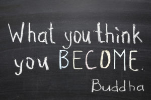 famous Buddha quote "What you think you become" handwritten on blackboard