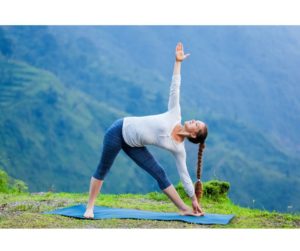 A serene image of a woman practicing yoga in an outdoor natural setting, surrounded by greenery, embodying natural remedies for menopause symptoms.