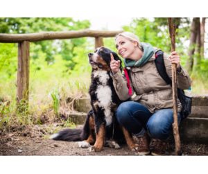 Woman enjoying a nature hike with her dog, representing the therapeutic benefits of nature in midlife.