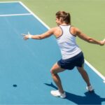 A person playing tennis on a sunny court, an active way to soak up Vitamin D as featured in 'The Sunshine Vitamin: 20 Ways to Boost Your D Levels Naturally'.