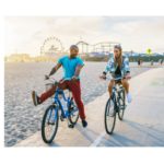 A couple enjoying a bike ride in sunny weather, an outdoor activity beneficial for Vitamin D intake, featured in 'The Sunshine Vitamin: 20 Ways to Boost Your D Levels Naturally' article.