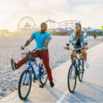 A couple enjoying a bike ride in sunny weather, an outdoor activity beneficial for Vitamin D intake, featured in 'The Sunshine Vitamin: 20 Ways to Boost Your D Levels Naturally' article.