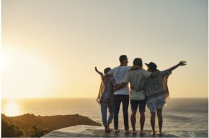 Sunset Embrace: A group of people in a warm, collective hug, gazing at a stunning sunset, illustrating the beauty of quality connections and the shared experience of life’s simple pleasures. 44 Simple Health Hacks.