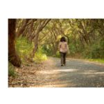 Healthy Stride: A woman walking along a scenic path, immersed in the tranquility of her surroundings, taking steps towards wellness and embodying an active lifestyle.