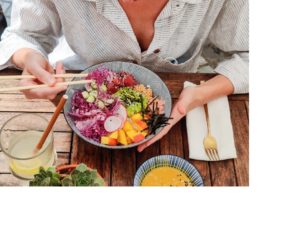 Wholesome Nourishment: A person sits before a meal abundant in vibrant, healthy foods, savoring a forkful of nutrition that represents a balanced diet for a healthy lifestyle.