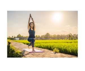 Serene Stretch: A woman in a peaceful setting practices a yoga pose, stretching towards the sky, embodying the harmony of mind and body through the art of yoga, enhancing flexibility and inner peace. The power of mindfulness. 