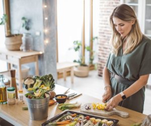 depicting a woman in her 30s to 50s cooking a healthy meal in the kitchen. This image aligns with the focus of your article, targeting a female audience and emphasizing the importance of using fresh ingredients in meal preparation.