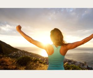  an image of a woman standing on a mountain peak with her arms outstretched conveys empowerment, freedom, and a sense of achievement.