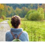 A woman walking peacefully through a lush forest, symbolizing a deep connection with nature and the tranquility it brings. Simple Habits for Happiness.