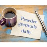 Image of a handwritten note on a wooden table with the message 'Practice Gratitude Everyday' to emphasize the importance of daily gratitude for a fulfilling life.Simple Habits for Happiness