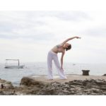 A woman practicing yoga by the ocean at sunrise, embodying self-care and harmony with nature. Simple Habits for Happiness,