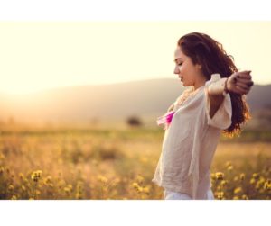 Image of a woman in a field with her arms open, symbolizing freedom and the benefits of the Anti-Inflammatory Diet.