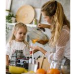 Time Hacks for Moms: A woman blending a shake for her child, using time-saving tools for quick and efficient meal preparation.