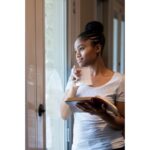 A woman peacefully savoring a cup of coffee, gazing out a sunny window, reflecting a moment of mindfulness and tranquility. Morning Routines: Start Your Day Right in 5 Minutes