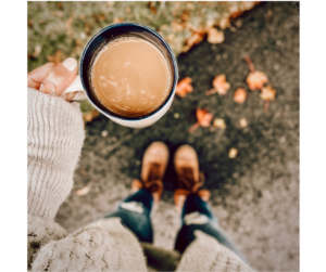 A woman's hands cradle a warm cup of cocoa, symbolizing a mindful moment of comfort in a cozy setting.