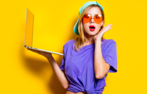 A woman wearing yellow glasses to reduce eye strain while working on her computer.