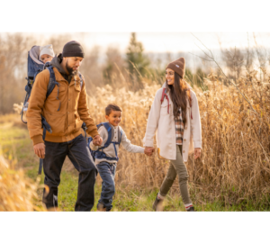 A family enjoys a serene walk through a vibrant autumn landscape, the crisp air and colorful leaves creating a perfect setting to unwind and enhance their mental health and sleep quality.