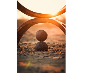 A balance symbol placed on a serene beach, representing harmony, emotional balance, and the calming effects of nature and frequency therapy.