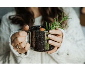 Woman holding a warm herbal mug as a symbol of calm, cozy self-care while learning how to choose a wellness gift.