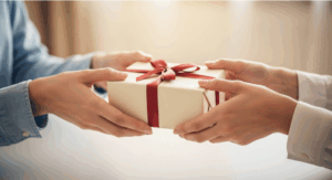 Two people exchanging a small wrapped present, representing how to choose a meaningful wellness gift. how to choose a wellness gift.