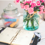 kitchen table, organizing her day with a planner.