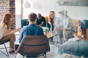 A diverse group of creative professionals engaged in a brainstorming session in a modern, well-lit office, demonstrating teamwork and emotional intelligence