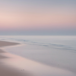 Serene beach scene at dawn with soft pastel colors in the sky, reflecting on the smooth water and sand, symbolizing peace and new beginnings. Real Self-Help for Everyday Life!