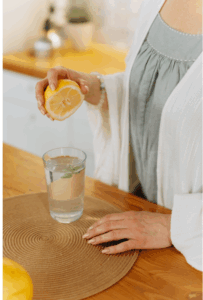 Woman holding lemon water – one of her simple summer habits for staying grounded